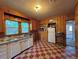 Vintage kitchen with checkered floor, wood paneling, and classic white appliances at 240 N 4Th Ave, Brighton, CO 80601