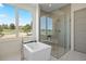 Bright bathroom featuring soaking tub, glass shower and scenic window at 6176 Oxford Peak Ln, Castle Rock, CO 80108