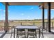 Covered deck with a dining table and picturesque views of the surrounding landscape at 6176 Oxford Peak Ln, Castle Rock, CO 80108