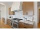 Modern kitchen features stainless steel range, marble backsplash, and light wood cabinets at 6176 Oxford Peak Ln, Castle Rock, CO 80108