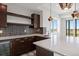 Kitchen featuring granite countertops, dark brown cabinets and hardware, tile backsplash, and stainless steel refrigerator at 6176 Oxford Peak Ln, Castle Rock, CO 80108