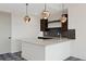 Bright kitchen featuring a white island, modern pendant lighting, and dark brown cabinets with sleek hardware at 6176 Oxford Peak Ln, Castle Rock, CO 80108