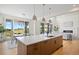 Modern kitchen featuring a large island, stylish pendant lights, and an open layout to the dining and living areas at 6176 Oxford Peak Ln, Castle Rock, CO 80108