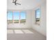 Bright living room with large windows providing outdoor views, modern light fixtures, and neutral carpeting at 6176 Oxford Peak Ln, Castle Rock, CO 80108