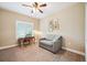 Bright bedroom featuring a comfortable seating area, desk, and a well-lit window with plantation shutters at 9744 W Ontario Pl, Littleton, CO 80128