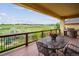 Outdoor deck with metal dining table and chairs overlooking a vast green landscape at 9744 W Ontario Pl, Littleton, CO 80128