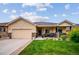 Beautiful tan single-story home featuring a well-manicured front yard and an attached two-car garage at 9744 W Ontario Pl, Littleton, CO 80128