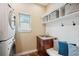 Well-organized laundry room with stacked washer/dryer, sink, and storage, maximizing space and functionality at 9744 W Ontario Pl, Littleton, CO 80128