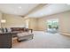 Spacious living room with neutral tones, comfortable seating, and access to an outdoor patio overlooking the landscape at 9744 W Ontario Pl, Littleton, CO 80128