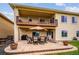 Covered patio with outdoor dining set, lounge chair, and landscaped yard area at 9744 W Ontario Pl, Littleton, CO 80128
