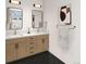 Bright bathroom with double sink vanity, modern fixtures, and decorative black tile flooring at 4512 Utica St, Denver, CO 80212