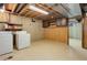 Basement laundry area with exposed ceiling, washer and dryer, and built-in cabinets for storage at 633 S Galena St, Denver, CO 80247
