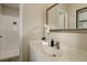 Bright bathroom featuring a clean vanity, sink, and shower area, all accented with decorative touches at 633 S Galena St, Denver, CO 80247