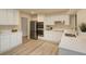 Modern kitchen with white cabinetry, stainless steel appliances, and laminate flooring at 633 S Galena St, Denver, CO 80247