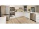 Bright kitchen boasts white cabinets, stainless appliances, and a window view at 633 S Galena St, Denver, CO 80247