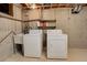 Functional laundry area featuring a utility sink, washer, and dryer with exposed pipes and concrete walls at 633 S Galena St, Denver, CO 80247
