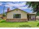 Home featuring a brick foundation and sunroom addition, surrounded by green grass at 633 S Galena St, Denver, CO 80247