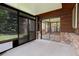 Sunroom with wood paneled ceiling and walls, exposed brick, and multiple glass doors at 633 S Galena St, Denver, CO 80247