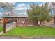 Exterior of a red brick house showing a grassy yard, brick patio and large tree at 2459 S Corona St, Denver, CO 80210