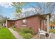 Side view of brick home featuring a landscaped yard, walkway, and seating area at 2459 S Corona St, Denver, CO 80210