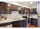 Well-equipped kitchen with stainless steel appliances, dark cabinets, and a functional layout for cooking and meal prep at 2459 S Corona St, Denver, CO 80210
