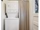 Laundry area showing the stacked washer and dryer, next to a window and striped curtain at 2459 S Corona St, Denver, CO 80210