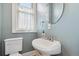 Cozy bathroom with a pedestal sink and window at 2617 Albion St, Denver, CO 80207