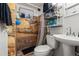Tiled bathroom featuring a shower, pedestal sink, and storage shelving at 8960 Judson St, Westminster, CO 80031