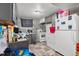 Galley kitchen with gray cabinetry, appliances, and adjacent laundry at 8960 Judson St, Westminster, CO 80031