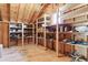 Large attic space with wooden beams, sloped ceilings, wood floors and built in shelving at 7390 Rafter Rd, Franktown, CO 80116