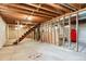 Unfinished basement space with exposed wood beams and staircase at 7390 Rafter Rd, Franktown, CO 80116