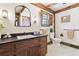 Bathroom featuring a dark wood vanity, decorative mirror, and vintage design at 7390 Rafter Rd, Franktown, CO 80116