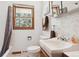 Bright bathroom featuring a white sink, toilet, and wooden framed window with natural light at 7390 Rafter Rd, Franktown, CO 80116