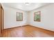 Empty bedroom with gleaming hardwood floors and two windows for ample natural light at 7390 Rafter Rd, Franktown, CO 80116