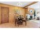 Cozy dining room featuring wood paneling, a fireplace, and a round glass-top table at 7390 Rafter Rd, Franktown, CO 80116