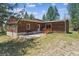 Charming single story home with wood siding, a small bench, and access ramp to the front door at 7390 Rafter Rd, Franktown, CO 80116