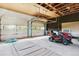 Spacious garage with a red lawn mower and white garage doors at 7390 Rafter Rd, Franktown, CO 80116