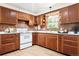 A functional kitchen offers lots of cabinet space and white appliances and brick backsplash at 7390 Rafter Rd, Franktown, CO 80116