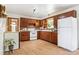 A functional kitchen offers lots of cabinet space and white appliances, ready for upgrades at 7390 Rafter Rd, Franktown, CO 80116