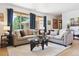 Inviting living room with comfortable seating, a glass coffee table, and natural light at 7390 Rafter Rd, Franktown, CO 80116