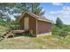 A quaint outbuilding features brown siding, a small porch, and a fenced yard at 7390 Rafter Rd, Franktown, CO 80116
