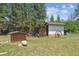 Outdoor sheds surrounded by lush greenery and tall trees on a spacious lot at 7390 Rafter Rd, Franktown, CO 80116
