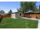 The backyard features a nice grass area with a patio with chairs at 2569 Forest St, Denver, CO 80207