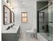 Modern bathroom featuring a double vanity, glass shower, and marble tile flooring at 2569 Forest St, Denver, CO 80207