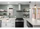 Stylish kitchen showcasing modern backsplash, stainless steel range hood, and white farmhouse sink at 2569 Forest St, Denver, CO 80207