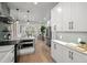 Open-concept kitchen flowing into living space, with stainless steel appliances and white cabinetry at 2569 Forest St, Denver, CO 80207