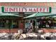Spinelli's Market featuring a red tiled roof, large window displays, and outdoor seating at 2569 Forest St, Denver, CO 80207