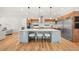 Open kitchen featuring an island with seating, stainless steel appliances, and modern wood cabinetry at 1490 S Vine St, Denver, CO 80210