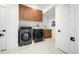 Convenient laundry room featuring a washer, dryer, sink, and storage cabinets at 1490 S Vine St, Denver, CO 80210