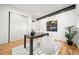 Bright office with hardwood floors, sleek black desk, modern art, and convenient closet storage at 1490 S Vine St, Denver, CO 80210